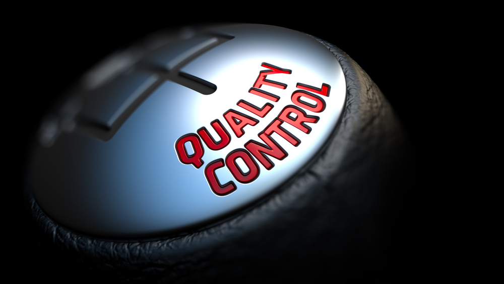 Quality Control - Red Text on Cars Shift Knob on Black Background. Close Up View. Selective Focus.